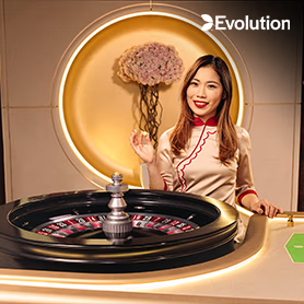 โต๊ะรูเล็ตสดพร้อมล้อหมุนและดีลเลอร์ในชุดคลาสสิก อยู่ในสตูดิโอฉากหลังสีทอง พร้อมโลโก้ Evolution Gaming